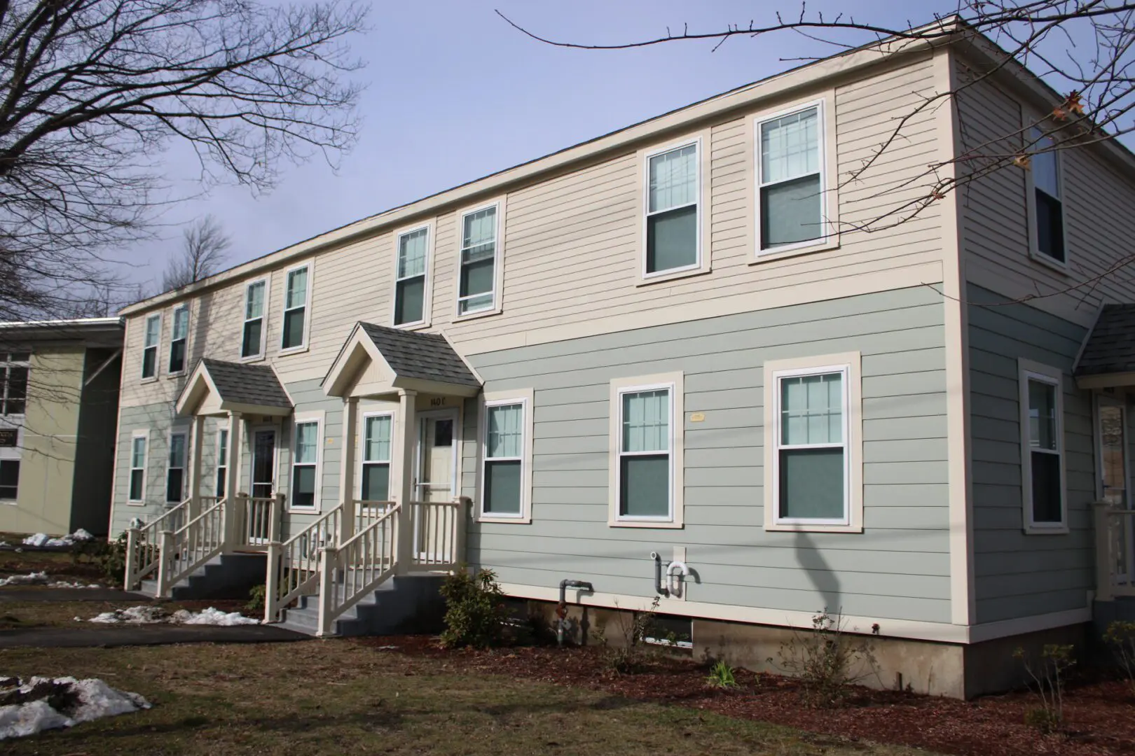 A row of houses with steps leading to the front.