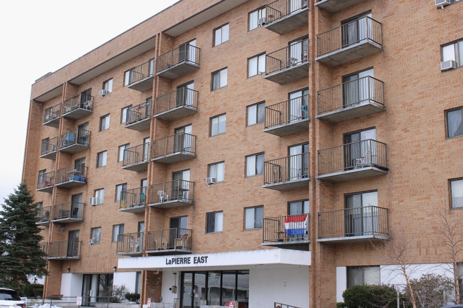 A large brick building with balconies and a sign.