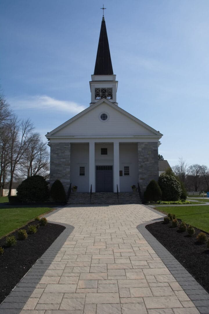 A church with a steeple and a large building.